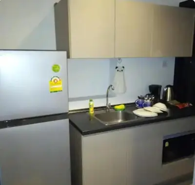 a kitchen with a sink and a refrigerator at Sky & River side view bts condo in Ban Sai Ma