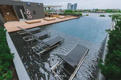 a swimming pool with two chairs and a table at Sky & River side view bts condo in Ban Sai Ma