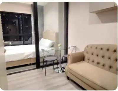a bedroom with a bed and a couch and a table at Sky & River side view bts condo in Ban Sai Ma