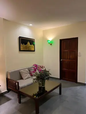 a living room with a couch and a table with flowers at Blue Chang House in Bangkok