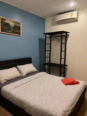 a bedroom with a bed and a room with a heater at Blue Chang House in Bangkok