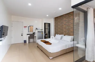 a bedroom with a large bed with a brick wall at Baron Zotel Bangkok SHA PLUS in Bangkok