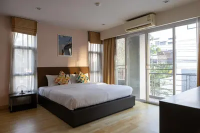 a bedroom with a large bed and a balcony at P Villa Lamoon Thonglor in Bangkok