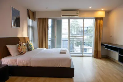 a bedroom with a large bed and a large window at P Villa Lamoon Thonglor in Bangkok