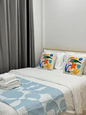 a bed with a blanket and pillows on it at MIQ HK256 5BR MRT Ratchada and HuaiKhwang in Bangkok