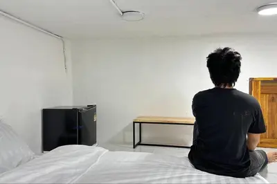 a man sitting on top of a bed at Megun capsule 150 cm in Bang O