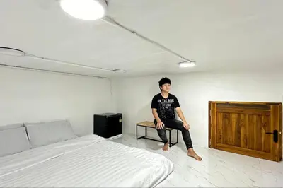 a man sitting on a table in a bedroom at Megun capsule 150 cm in Bang O