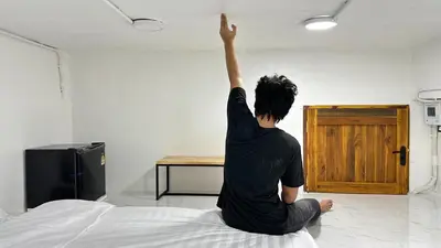 a man sitting on a bed with his arm in the air at Megun capsule 150 cm in Bang O