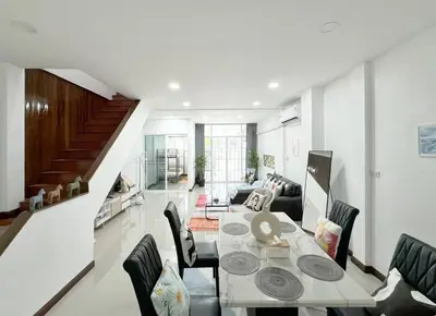 a dining room and living room with a table and chairs at MIQ HK611 Huai Khwang 4BR Jodd fair in Bangkok