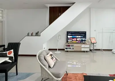 a living room with a chair and a tv at MIQ HK611 Huai Khwang 4BR Jodd fair in Bangkok