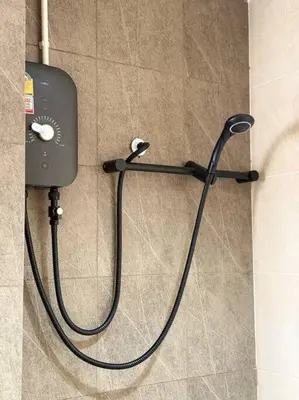 a shower hose hooked up to a dispenser on a wall at Miq Asoke 5BR Sukhuvit15 in Makkasan