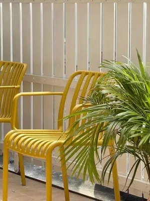 a yellow chair sitting next to two plants at Miq Asoke 5BR Sukhuvit15 in Makkasan