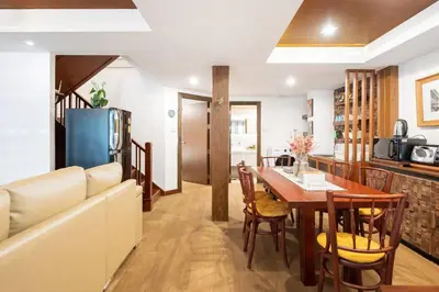 a kitchen and dining room with a table and a couch at MIQ Rama9 Villa 3Br in City Jodd fair MRT in Makkasan