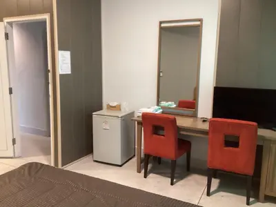 a room with a desk with two chairs and a mirror at Ther Bangkoknoi Hotel in Bangkok Noi