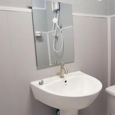 a white sink in a bathroom with a mirror at Ther Bangkoknoi Hotel in Bangkok Noi