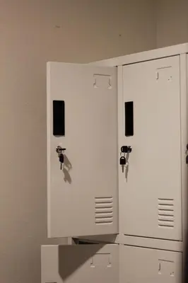 two white cabinets with keys on them next to a wall at Round The Clock Hostel in Samphanthawong