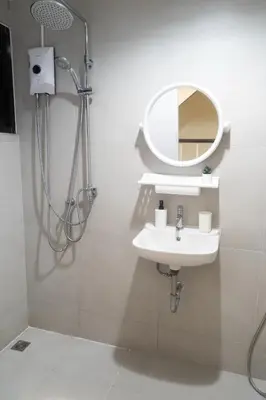 a bathroom with a sink and a mirror at Round The Clock Hostel in Samphanthawong
