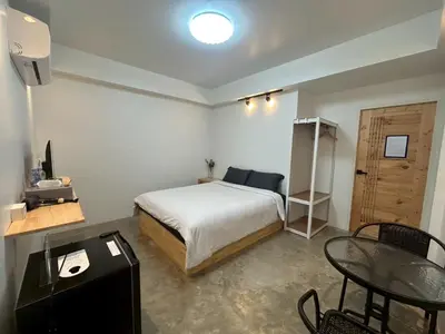 a bedroom with a bed and a table and chairs at Choose me guesthouse in Bang Kruai