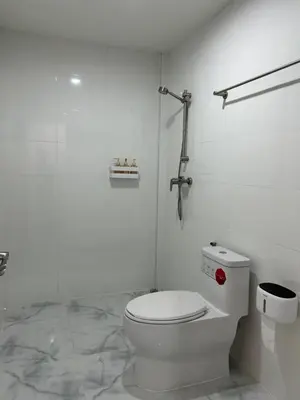 a white bathroom with a toilet and a shower at Choose me guesthouse in Bang Kruai