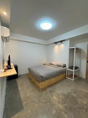 a bedroom with a bed and a desk with a computer at Choose me guesthouse in Bang Kruai