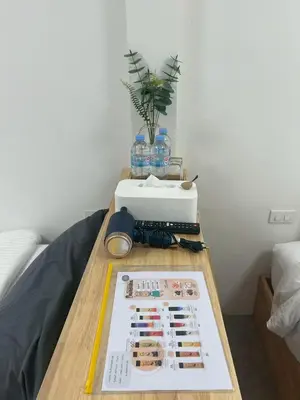 a table with a magazine on top of a bed at Choose me guesthouse in Bang Kruai