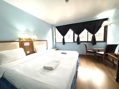 a bedroom with a large bed and a table and chairs at XX Wish Inn BTS Chidlom - วิช อินน์ บีทีเอส ชิดลม in Pratunam