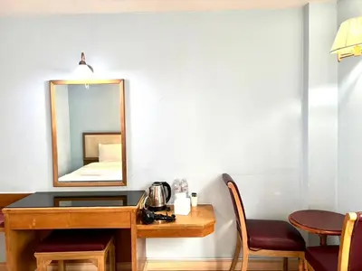 a vanity with a mirror and a table with chairs at XX Wish Inn BTS Chidlom - วิช อินน์ บีทีเอส ชิดลม in Pratunam