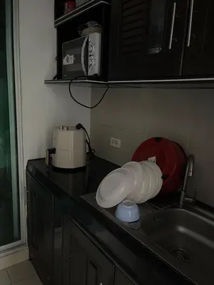 a kitchen counter with a sink and a microwave at Love Nest in Bangkok
