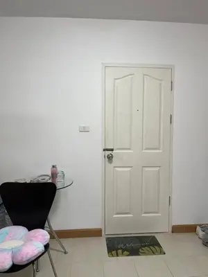 a white door in a room with a table and a chair at Love Nest in Bangkok