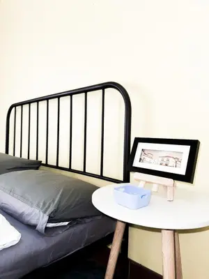 a bed with a table next to a bed with a bed frame at Titi-pon Apartment Bang Khen in Bang Khen