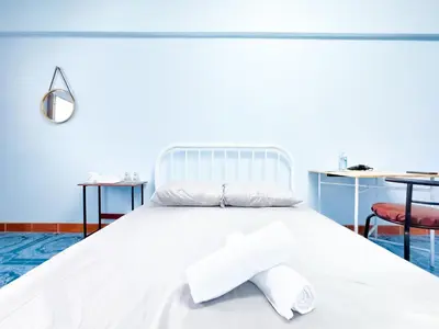 a white bed with a cross on it with two tables at Titi-pon Apartment Bang Khen in Bang Khen