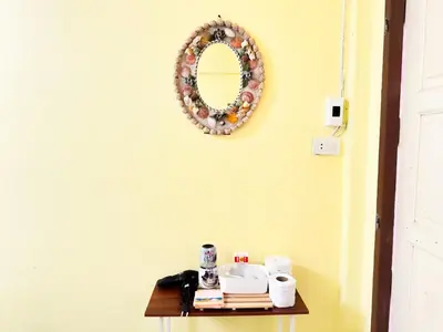 a table with a mirror on a yellow wall at Titi-pon Apartment Bang Khen in Bang Khen