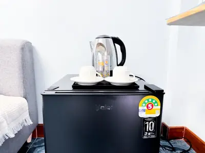 a coffee maker sitting on top of a black refrigerator at Titi-pon Apartment Bang Khen in Bang Khen