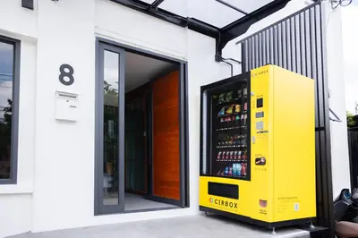 a yellow vending machine on the side of a building at DMK Place in Bangkok
