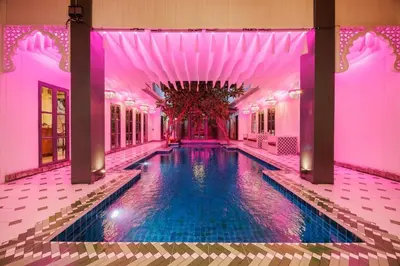 a swimming pool in a building with a pink ceiling at \u83f2\u65af\u4e4b\u57ce\u66fc\u8c371200\u5e73\u7687\u5bb6\u68ee\u7cfb\u6cf3\u6c60\u6d3e\u5bf9\u522b\u5885 in Bangkok