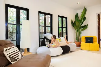 a woman sitting on a couch in a living room at \u8fea\u5965\u82b1\u56ed\u66fc\u8c37\u661f\u7a7a\u6cf3\u6c60\u82b1\u56ed\u6d3e\u5bf9\u522b\u5885 in Bangkok