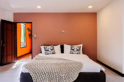 a bedroom with a large bed and an orange wall at \u8fea\u5965\u82b1\u56ed\u66fc\u8c37\u661f\u7a7a\u6cf3\u6c60\u82b1\u56ed\u6d3e\u5bf9\u522b\u5885 in Bangkok