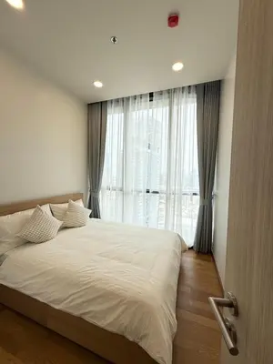 a bedroom with a large bed and a large window at Brand New Condo in Bangkok