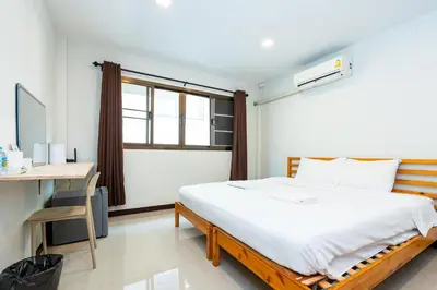 a bedroom with a bed and a desk and a window at The Hidden Giant Swing เดอะ ฮิดเด้น เสาชิงช้า in Bangkok