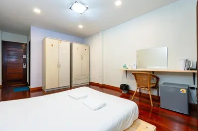 a bedroom with a bed and a desk and a chair at The Hidden Giant Swing เดอะ ฮิดเด้น เสาชิงช้า in Bangkok
