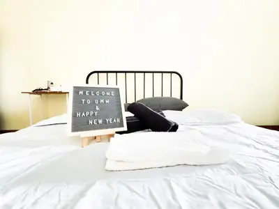 a sign sitting on top of a white bed at ฐิติพร อพาร์ทเมนต์ บางเขน in Tha Akatsayan Don Muang