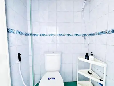 a white bathroom with a shower and a toilet at ฐิติพร อพาร์ทเมนต์ บางเขน in Tha Akatsayan Don Muang