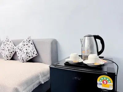 a coffee maker on a table next to a bed at ฐิติพร อพาร์ทเมนต์ บางเขน in Tha Akatsayan Don Muang