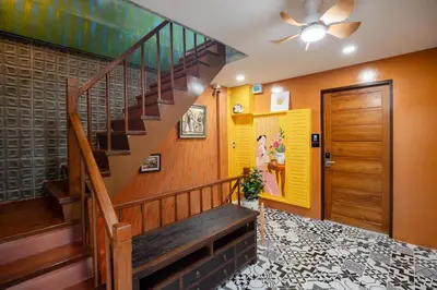 a hallway with a staircase and a yellow door at BB Boutique Sathorn in Bangkok