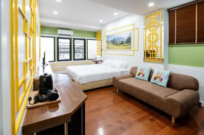a hotel room with a bed and a couch at BB Boutique Sathorn in Bangkok