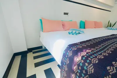 a bedroom with a large white bed and pink pillows at The Locals Bangkok Old Town in Bangkok