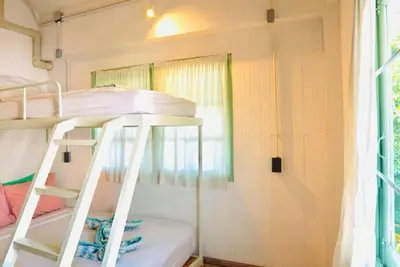 a bunk bed in a small room with a window at The Green Khaosan Bangkok in Bangkok
