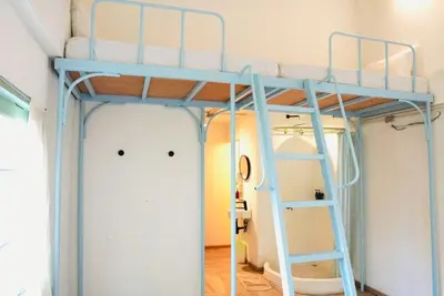 a bunk bed in a room with a ladder at The Green Khaosan Bangkok in Bangkok