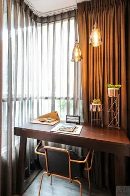 a desk with two chairs in front of a window at brown condo Phahon67 in Ban Chuat Plai Mai