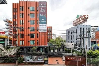 a tall orange building in the middle of a city at brown condo Phahon67 in Ban Chuat Plai Mai